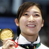 Rikako Ikee holds her gold medal after winning the women\'s 50-meter freestyle final at the Asian Games on Aug. 24, 2018, in Jakarta. On Wednesday, Ikee thanked fans for the messages of support she has gotten since announcing her leukemia diagnosis on Tuesday. | AP