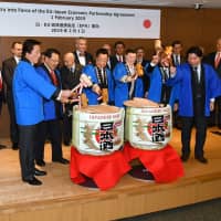 On Feb. 1, European Union Ambassador Patricia Flor (front row, third from right) breaks open a sake barrel at the Delegation of the European Union to mark the beginning of the enforcement of the EU-Japan Economic Partnership Agreement together with (from left) House of Representatives Foreign Affairs Committee Chairman Kenji Wakamiya; State Minister of Economy, Trade and Industry Yoshihiro Seki; Agriculture, Forestry and Fisheries Minister Takamori Yoshikawa; Okinawa and Northern Territories Affairs Minister Mitsuhiro Miyakoshi; and Parliamentary Vice Finance Minister Shinichi Isa. | YOSHIAKI MIURA
