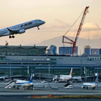 Photographers will soon be unable to take photos such as this one, of planes taking off in front of Mount Fuji at Haneda airport in Ota Ward, Tokyo, as the runway will only be used for landings from the end of March due to noise pollution. | KYODO