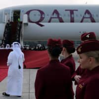 Qatar Airways cabin crew stand in front of an Airbus A350-1000 at Hamad International Airport in Doha last year. | REUTERS