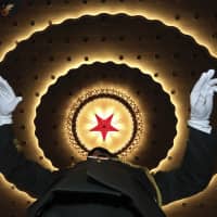 A Chinese military band conductor rehearses before the opening session of the annual National People\'s Congress in Beijing\'s Great Hall of the People on Tuesday. | AP