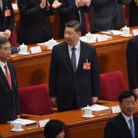Chinese President Xi Jinping stands with Premier Li Keqiang (right) and Politburo Standing Committee member Wang Yang at the opening session of the National People\'s Congress in Beijing on Tuesday. | AFP-JIJI