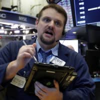 Trader Michael Milano works on the floor of the New York Stock Exchange on Thursday. U.S. stocks moved lower in morning trading, led by banks and technology companies, putting the market on track for its first losing week since January. | AP