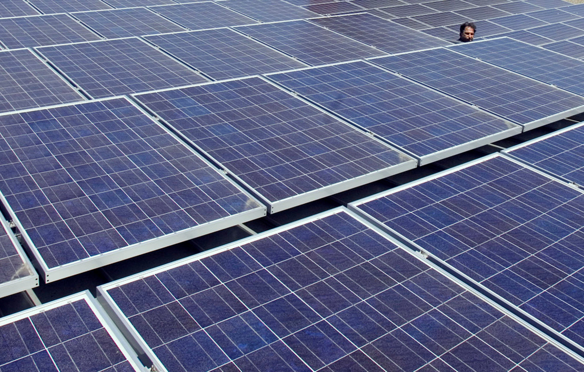 A man views solar panels on a roof at Google headquarters in Mountain View, California, in 2007. | REUTERS