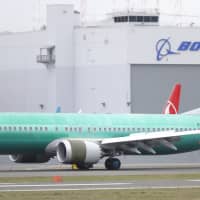 A Boeing 737 MAX 8 being built for Oman Air taxis past a Boeing hanger after landing at Boeing Field, Friday in Seattle. | AP
