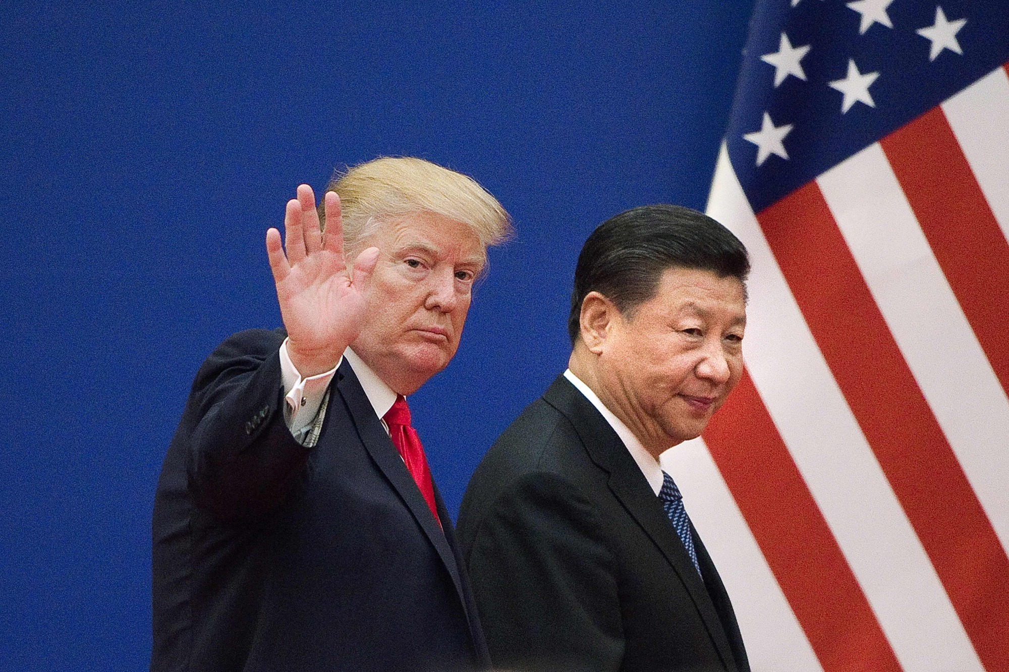 U.S. President Donald Trump waves as he and Chinese President Xi Jinping leave a business leaders event at the Great Hall of the People in Beijing in 2017. Trump on Friday urged China to abolish tariffs on agricultural products imported from the United States &#8212; adding that trade talks between the rival powers were going well. | AFP-JIJI
