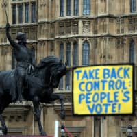 An anti-Brexit sign is seen next to a statue of King Richard I outside the Houses of Parliament in London on Monday. | REUTERS