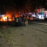 Rescuers run as they carry a stretcher in Mogadishu Thursday after a car bomb exploded close to a major hotel killing at least five people and wounding 25 others. Witnesses described how the blast ripped through one of the busiest streets of the capital in the early evening, filled with people relaxing after a day at work. | AFP-JIJI