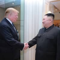 U.S. President Donald Trump and North Korean leader Kim Jong Un shake hands as they meet at a Hanoi hotel on Thursday. | AFP-JIJI