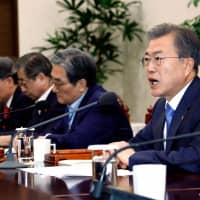 South Korean President Moon Jae-In (right) presides over a meeting of the National Security Council at the presidential Blue House in Seoul on Monday. Moon urged the U.S. and North Korea to quickly resume denuclearization talks after their Hanoi summit last week ended without a deal. | YONHAP / VIA AFP-JIJI