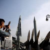 A man takes photographs of mock missiles at the Korean War Memorial Museum in Seoul Feb. 28. | REUTERS