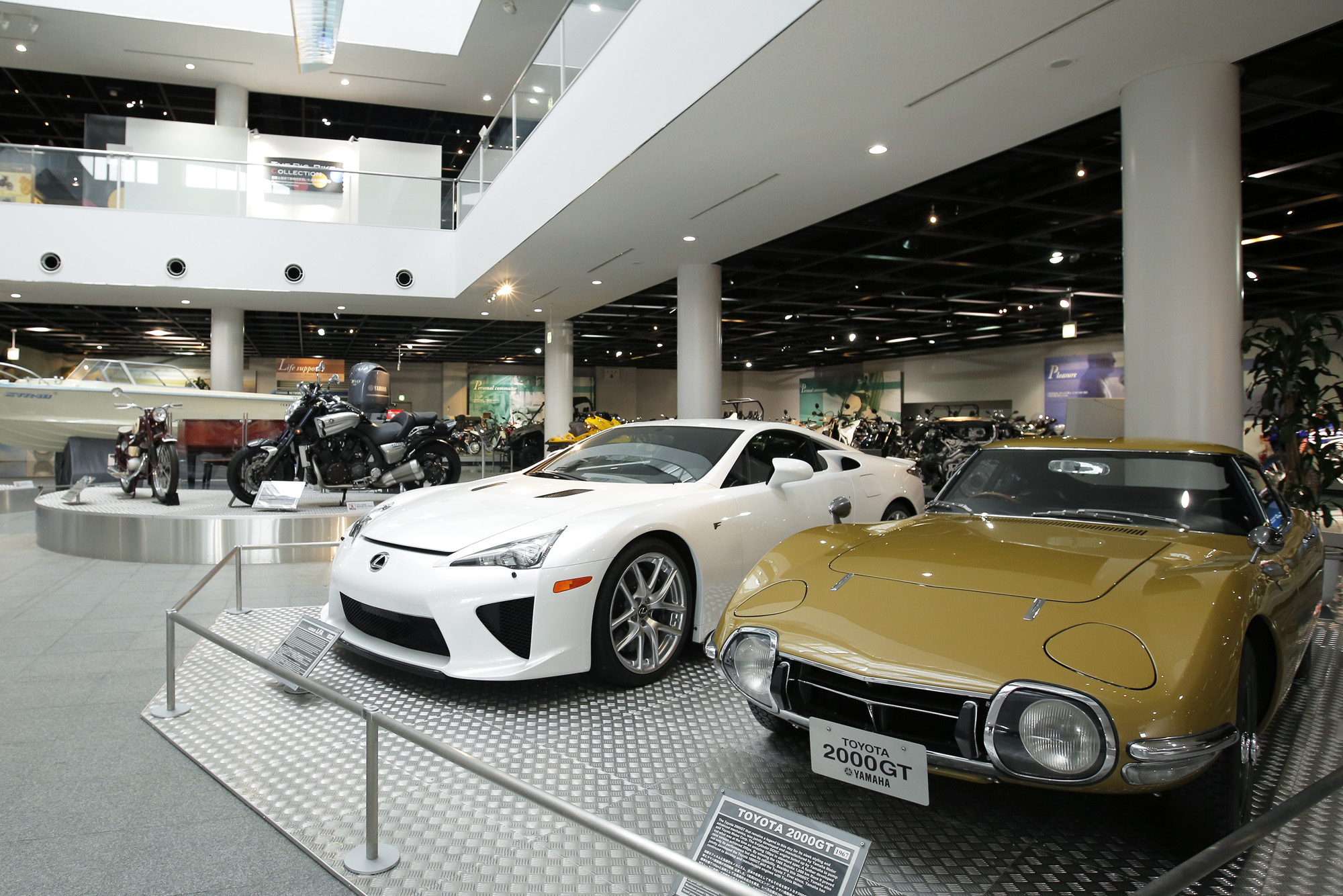 A Toyota 2000GT coupe (right) is displayed in a Yamaha Motor Co. showroom in Iwata, Shizuoka Prefecture, in February 2015. | BLOOMBERG
