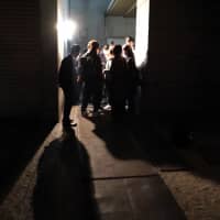 Mehmet Colak\'s family and activists question officers at the rear entrance of the immigration center about his condition. | CHISATO TANAKA