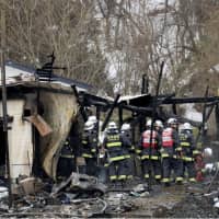 Firefighters gather at a farm in Hirosaki, Aomori Prefecture, on Monday after a fire there left four people dead. | KYODO