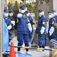 Police investigate the scene where a Japanese woman was stabbed to death in the lobby of the Tokyo Family Court building on Wednesday. Her American husband was arrested nearby. | KYODO