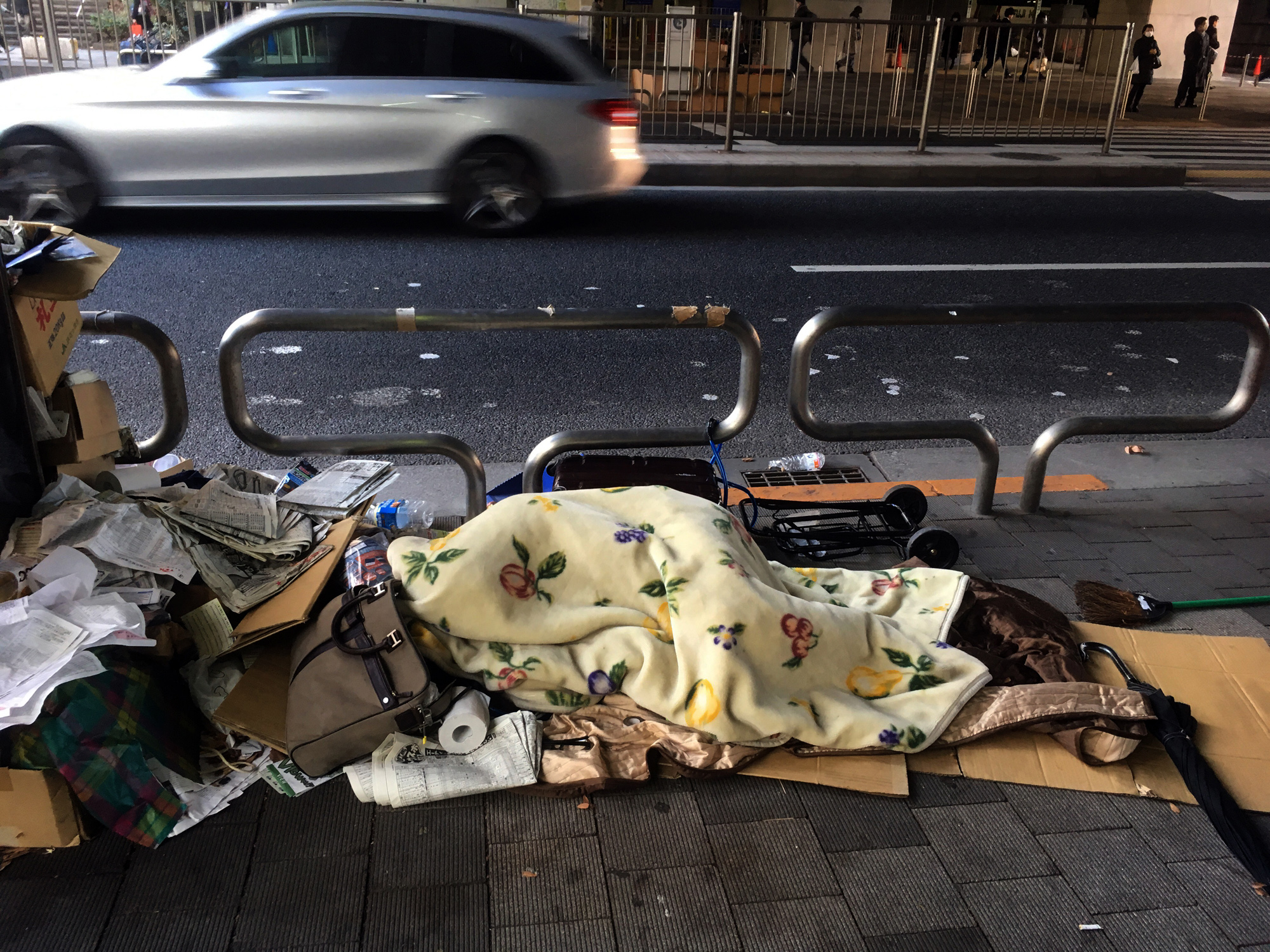 Living day by day: A homeless man lies on a street in Tokyo's Shinjuku district in January. | YOSHIAKI MIURA