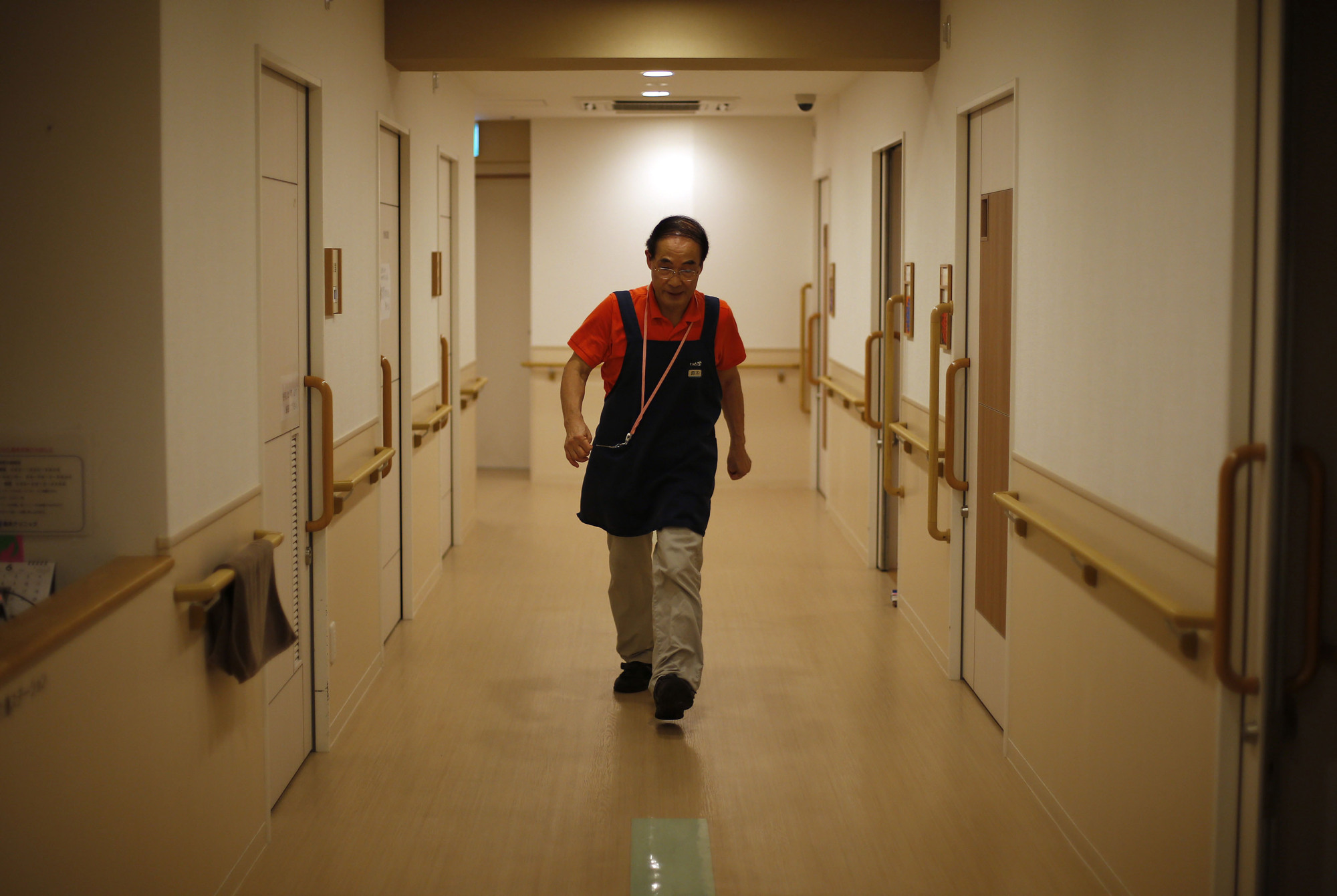 A 72-year-old caregiver works a nursing home in Tokyo. As the population grays and shrinks, increasing the participation of elderly people in Japan's labor market is indispensable to achieving sustainable economic growth. | BLOOMBERG