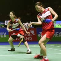 Ayaka Takahashi (right) plays a shot as doubles partner Misaki Matsutomo looks on at the All England Open Badminton Championships on Wednesday in London. | KYODO