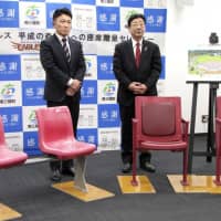 Rakuten Eagles president Yozo Tachibana and Minamisanriku mayor Jin Sato pose with seats that will be donated to a local baseball stadium in Minamisanriku, Miyagi Prefecture, on Monday. | KYODO