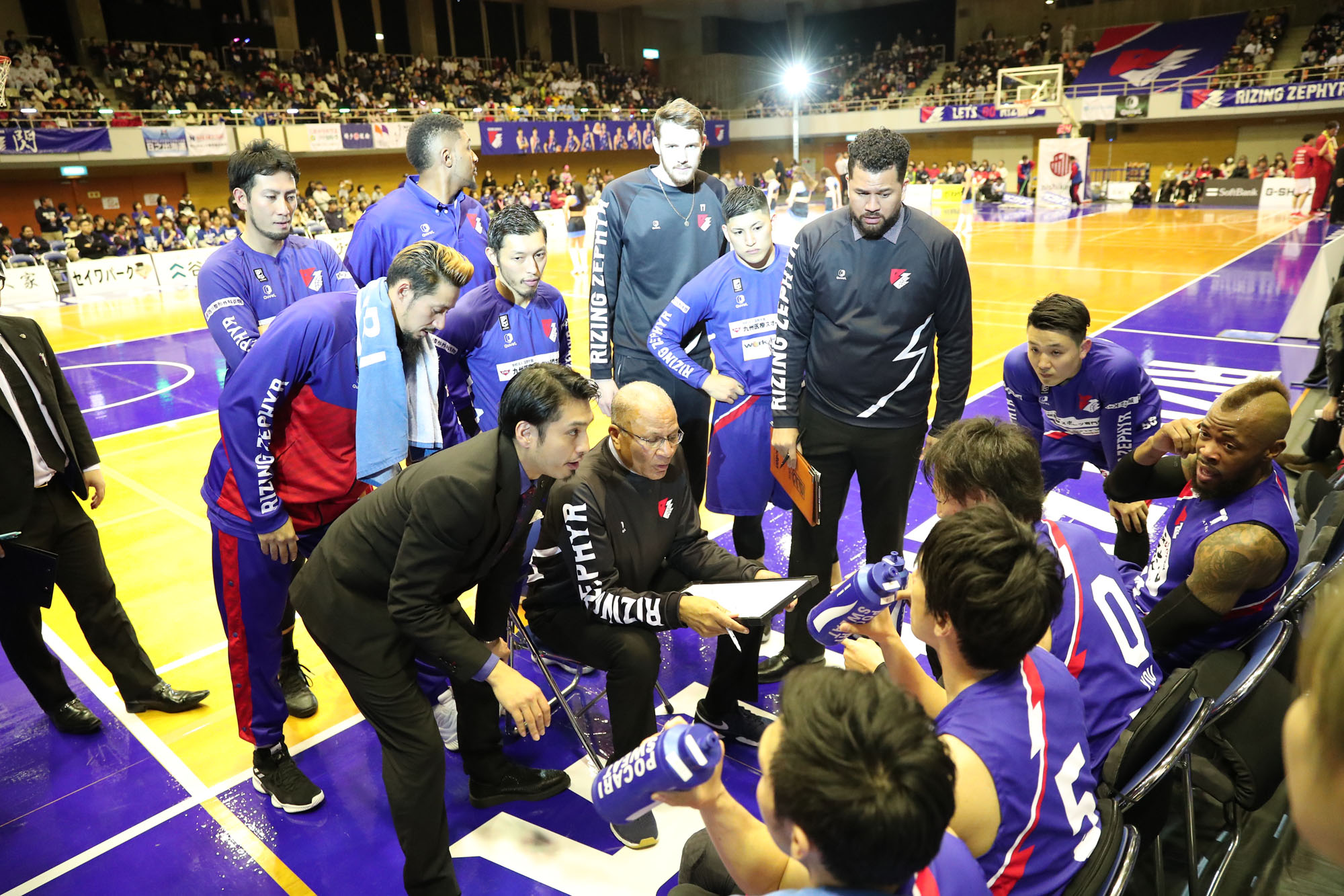 Fukuoka head coach Bob Nash and Jun Nakanishi, an assistant/team translator who became general manager last week, are seen talking to Rizing Zephyr players during last Saturday's game. | B. LEAGUE
