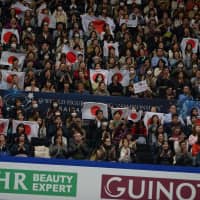 Fans hold up Japanese flags before Satoko Miyahara\'s short program Wednesday at Saitama Super Arena. | DAN ORLOWITZ