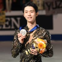 Yuzuru Hanyu poses with his silver medal at figure skating world championships Saturday in Saitama. | DAN ORLOWITZ
