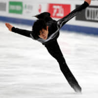 Nathan Chen competes to \"Land of All\" in the men\'s free skate at the World Figure Skating Championships on Saturday night at Saitama Super Arena. Chen retained his title with 323.42 points. | REUTERS