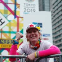 Vanessa Oshima, a cancer survivor from New Zealand who lives in Japan, catches her breath at the finish line of the Tokyo Marathon on Sunday. | RYUSEI TAKAHASHI