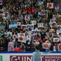 Fans hold up banners and Japanese flags after Yuzuru Hanyu\'s short program. | DAN ORLOWITZ