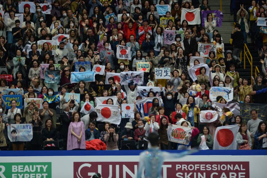 Fans hold up banners and Japanese flags after Yuzuru Hanyu