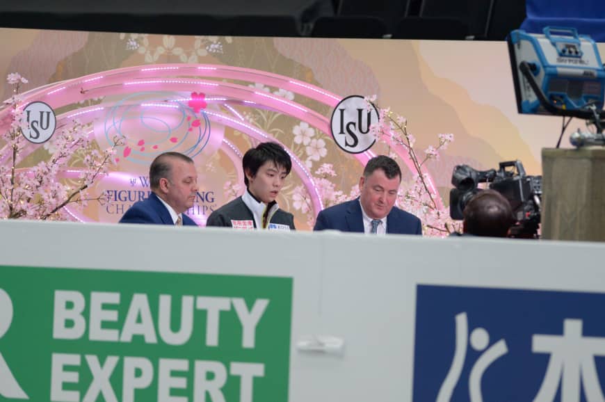 Yuzuru Hanyu (center) awaits his results in the area known as the 