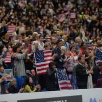 Fans holding U.S. flags give Nathan Chen a standing ovation after his performance. | DAN ORLOWITZ