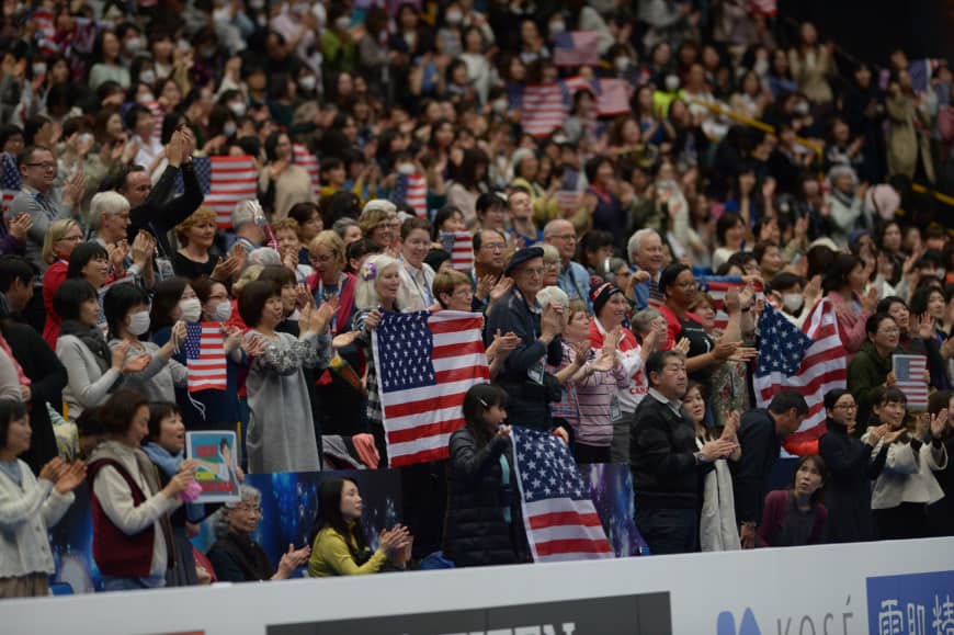 Fans holding U.S. flags give Nathan Chen a standing ovation after his performance.