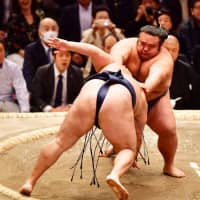 Sekiwake Takakeisho (right) pushes down yokozuna Kakuryu on the 10th day of the Spring Grand Sumo Tournament on Tuesday in Osaka. | NIKKAN SPORTS