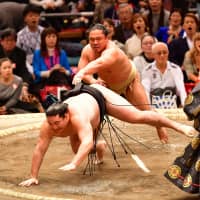 No. 15 maegashira Ishiura, one of the two Nihon University products in the current makuuchi division, throws down 11th-ranked maegashira Ryuden on Monday. | NIKKAN SPORTS