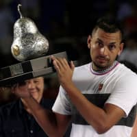 Nick Kyrgios holds the trophy after winning the Mexican Open on Sunday. | REUTERS