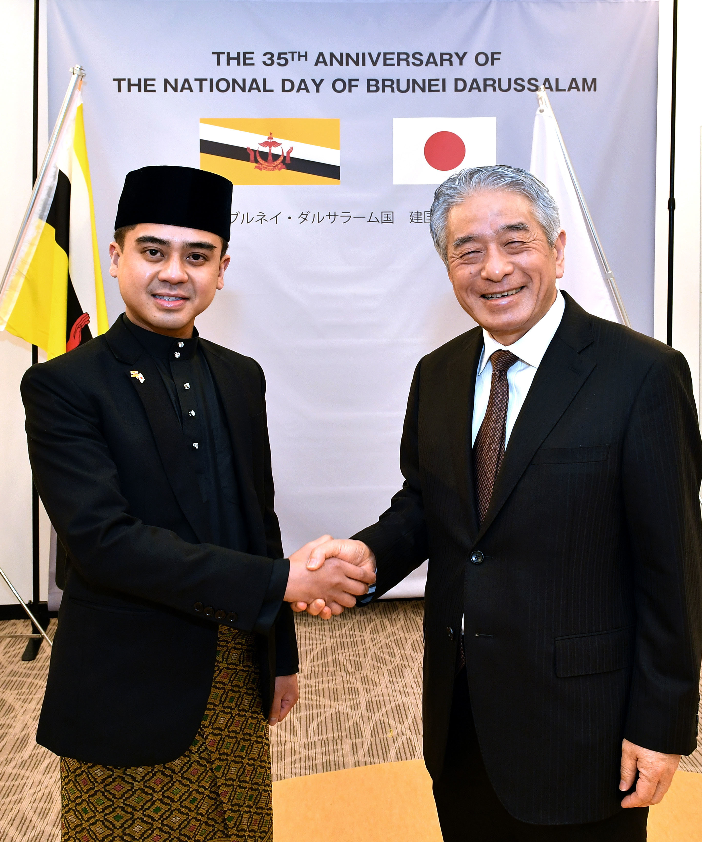 Ian Maidin, Brunei charge d'affaires ad interim (left), shakes hands with Masataka Fujita, secretary general of the ASEAN-Japan Centre, during a reception to celebrate Brunei Darussalam's 35th national day at the ASEAN-Japan Centre on Feb. 28. |  YOSHIAKI MIURA