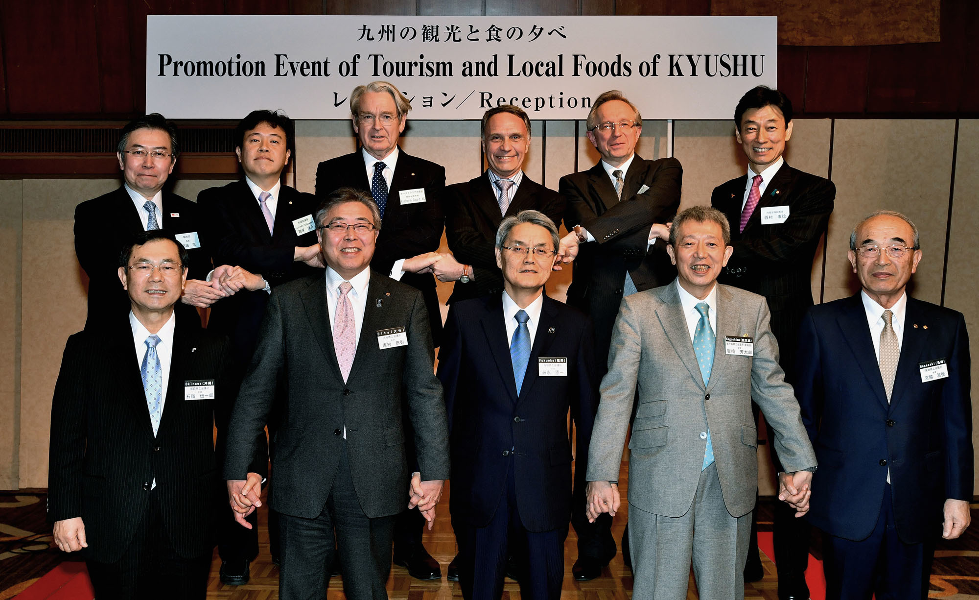 Australian Ambassador Richard Fairfax Court (back row, third from left); Argentinian Ambassador Alan Claudio Beraud (back row, third from right); and Russian Ambassador Mikhail Y. Galuzin (back row, second from right), who are each ambassadors of countries participating in the 2019 Rugby World Cup, pose with (back row, from left) Commissioner of the Japan Tourism Agency Hiroshi Tabata; Diet members Yosuke Tsuruno and Yasutoshi Nishimura; Chairman of the Fukuoka Chamber of Commerce and Industry Kenichi Fujinaga (front row, center); Chairman of the Kagoshima Chamber of Commerce and Industry Yoshitaro Iwasaki (front row, second from right); and others during an event promoting tourism and local foods of Kyushu at the Tokyo Prince Hotel on March 19. | YOSHIAKI MIURA