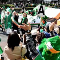 \"St. Patrick\" walks beside Irish Ambassador Paul Kavanagh (right) and Culture Minister Josepha Madigan in the St. Patrick\'s Day Parade on Omotesando-dori in Tokyo\'s Harajuku district on Sunday. About 1,530 people took part in the parade, which attracted 50,000 visitors. | YOSHIAKI MIURA