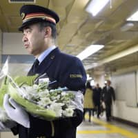 A senior Tokyo Metro Co. official lays flowers at Kasumigaseki Station Wednesday, the 24th anniversary of the deadly sarin nerve gas attack by the Aum Shinrikyo cult, which killed 13 people and injured more than 6,000 others in the Tokyo subway system. | KYODO