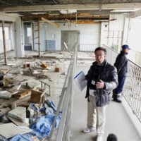 A storyteller standing in the ruins of Kesennuma Koyo High School on Friday explains the impact on communities along the coast of Kesennuma, Miyagi Prefecture, when deadly tsunami hit on March 11, 2011. The building will be reopened for public viewing from March 10. | KYODO