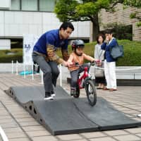 Seiji Kato, 4, rides a bike during a BMX demonstration at a promotional event for the 2020 Olympic Games held at the Tokyo Stock Exchange on Saturday. | RYUSEI TAKAHASHI