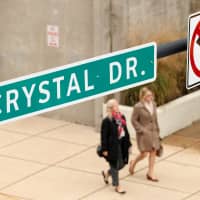 Women pass under a sign in Crystal City where Amazon announced its new headquarters would be based in Arlington, Virginia, last November. | REUTERS