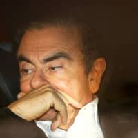 Former Nissan Chairman Carlos Ghosn sits in a car after leaving his lawyer\'s office in Tokyo on March 6, the day he was released on bail. | REUTERS