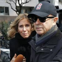 Former Nissan Motor Co. Chairman Carlos Ghosn and his wife, Carole, are seen outside their Tokyo apartment on March 9. | KYODO