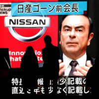 Passersby are silhouetted as a huge street monitor broadcasts news reporting ousted Nissan Motor chief\'s Carlos Ghosn\'s indictment and re-arrest in Tokyo in December. | REUTERS