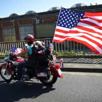 A Harley-Davidson biker drives with a dog in Tours, France, during a parade at the American Tours Festival last July. U.S. President Donald Trump threatened retribution on Europe Tuesday over tariffs that have bruised profitability at iconic U.S. motorcycle company Harley-Davidson. | AFP-JIJI