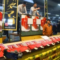 Premium mangoes called Taiyo no Tamago are auctioned at a wholesale market in Miyazaki Prefecture on Monday. | KYODO
