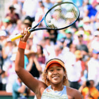 Naomi Osaka smiles after she claims her first career title at the BNP Paribas Open in March 2018. | GETTY IMAGES / VIA KYODO