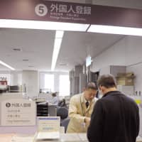 A foreign resident registers at a ward office in Osaka. | KYODO